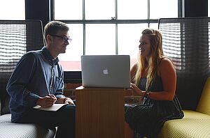 Zwei Personen im Gespräch während eines Business-Meetings – individuelle Sprachschulberatung für Unternehmen bei tricos Bildung